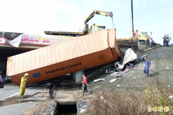 貨櫃車和大貨車擦撞後，衝過護欄掉落平面道路與護坡。（記者蔡宗勳攝）