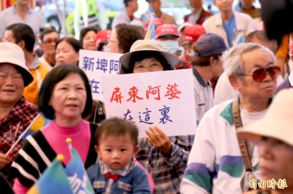 朱立倫今天上午前往屏東六堆忠義祠參拜，現場挺朱民眾拿著「屏東阿婆在這裏」標語。（記者邱芷柔攝）