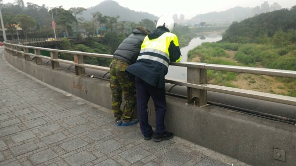 員警在橋面上細心開導藍某。（記者徐聖倫翻攝）