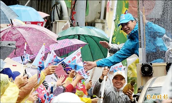 國民黨總統候選人朱立倫（右）昨日陪同新北市中永和、新店地區的黨籍立委候選人車隊掃街拜票，大批支持者冒雨站在路邊搖旗歡迎。（記者王敏為攝）