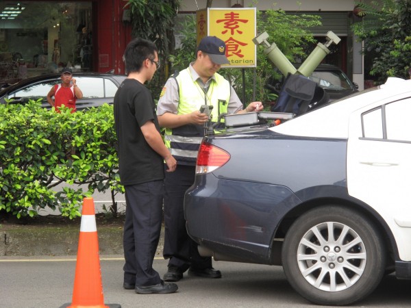 新竹縣一名酒駕肇事的謝姓男子竟辯稱是妻子開車，警方調閱監視畫面後戳破謊言，除了公共危險罪，另依意圖使公務人員登載不實及頂替罪嫌，將謝男移送法辦。圖為警方攔車酒測照。（記者廖雪茹翻攝）