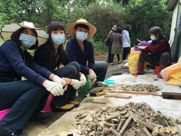 從事美髮業的陳榮任帶著老婆及女兒一起幫忙洗、刷無主骨骸。（記者黃淑莉攝）