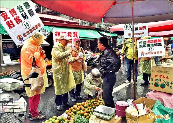 台聯黨主席黃昆輝（左二）昨冒雨在東市場等處，向攤商、店家爭取政黨票。（記者陳璟民攝）