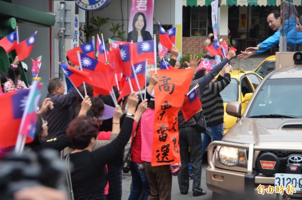 朱立倫在戰車上與支持者握手致意。（記者陳鳳麗攝）