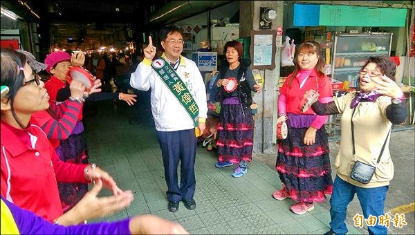 黃偉哲到新化市場拜票，巧遇婆婆媽媽快閃團。（記者劉婉君攝）