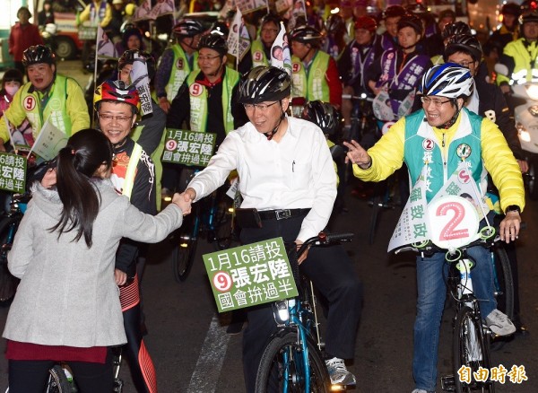 台北市長柯文哲（中）14日晚間陪同民進黨立委候選人張宏陸（左）、羅致政（右），以騎單車的方式掃街拜票。（記者羅沛德攝）
