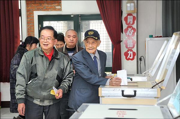 苗栗縣最高齡男人瑞、107歲的彭進添(右)一身西裝筆挺,到投開票所投下神聖的一票。(記者張勳騰攝) 苗栗縣最高齡男人瑞、107歲的彭進添(右)一身西裝筆挺,到投開票所投下神聖的一票。(記者張勳騰攝)