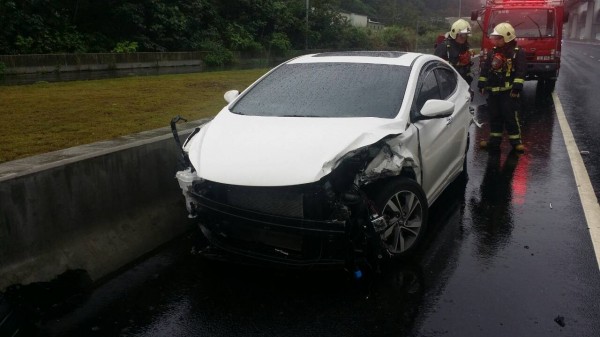 白色小轎車疑天雨路滑翻覆，所幸駕駛幸運無傷。（記者曾健銘翻攝）