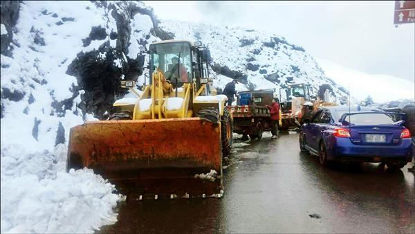 合歡山昨天放晴與氣溫回升，公路總局埔里工務段出動大型剷雪車清除路面積雪與結冰。（仁愛分局提供）