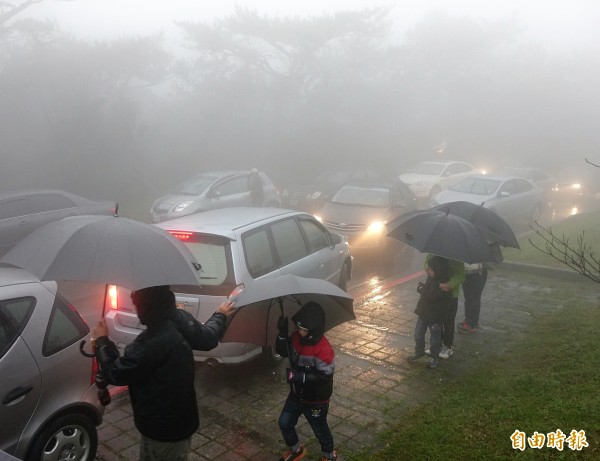 今天許多民眾前往陽明山等待下雪，根據鞍部氣象站回報，今晚6點01分時，陽明山已經開始降雪。（記者方賓照攝）