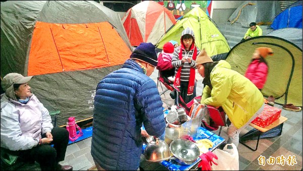 來自高雄、台南的跑友們，忍著攝氏五度低溫，在尖石鄉公所對面、文化館前搭帳棚炊煮，等著今天極可能出現的「雪地馬拉松」挑戰。（記者黃美珠攝）