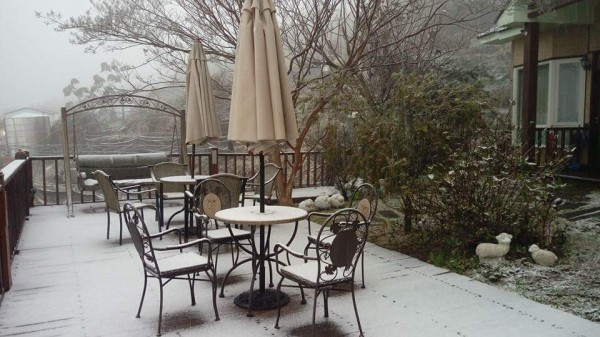 網友Richel拍下清境民宿飄雪，地上染白的美景。（圖截自合歡山賞雪機動團臉書社團）