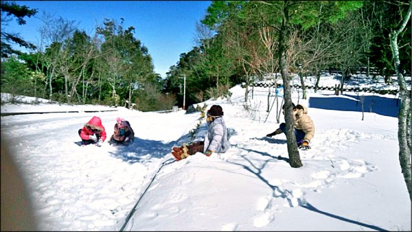 滯留在雪霸國家公園觀霧遊憩區的遊客，把握離開前的最後機會，開心地丟雪球、打雪仗。（警方提供）