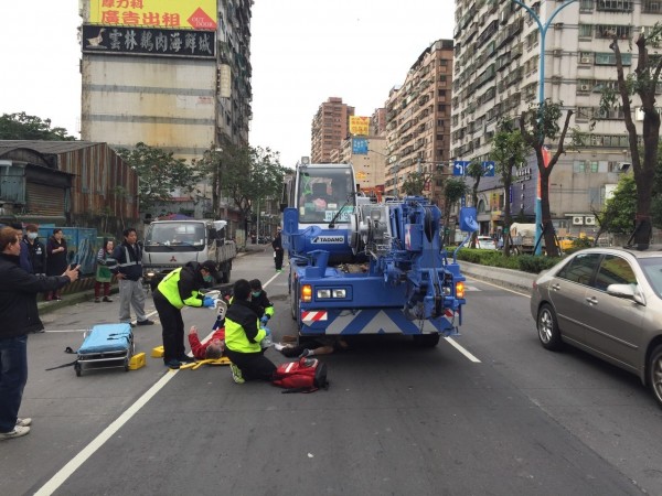 石婦遭吊車右前輪輾過，救護人員到場搶救。（記者余衡翻攝）