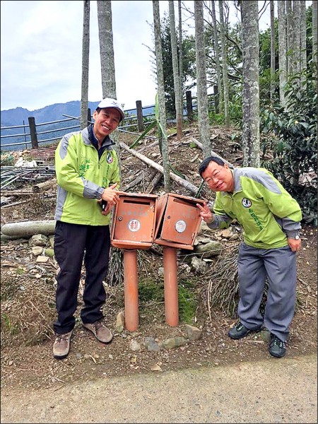 南投縣議員陳昭煜（右）和秘書謝承宗（左）日前到水里鄉頂崁村會勘，路上意外發現一對信箱貌似去年爆紅的「歪腰郵筒」，二人還逗趣的上前合照。（取自謝承宗臉書）