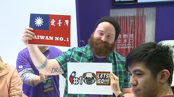 「台灣No.1」老外今天現身台北電玩展，吸引大批粉絲與他簽名、合影，還有粉絲特別批著國旗前來，甚至送他國旗。（中央社）