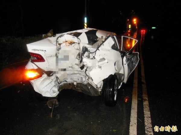 轎車打滑失控車尾與路樹撞的正著，後車廂也被擠壓出明顯的半圓形凹痕。（記者劉濱銓攝）