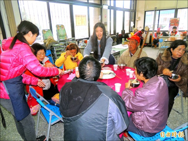 三義高中餐飲科學生下廚做菜，宴請獨居老人歡喜圍爐，還提供夾菜隨桌服務。（記者蔡政珉攝）