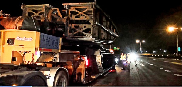 一輛託運國軍工兵橋車的拖板車，行駛時疑靠近路中間，工兵橋車不慎撞斷路燈與路牌。（記者王駿杰翻攝）