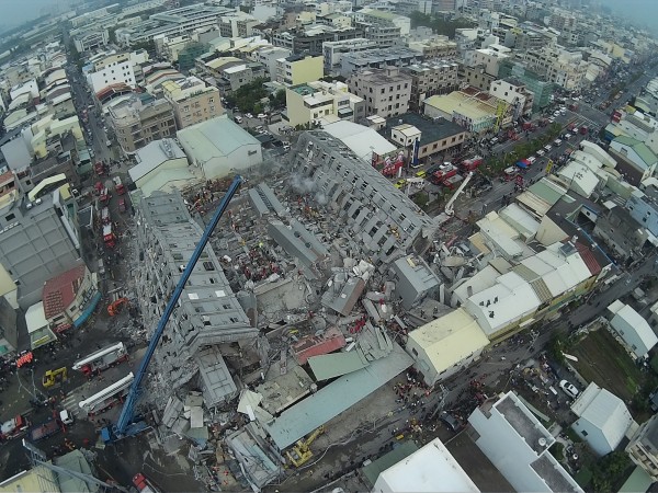 台南永康區永大路一棟大樓因凌晨強震而倒塌，消防救難人員全力搜救受困民眾。（記者黃志源攝）