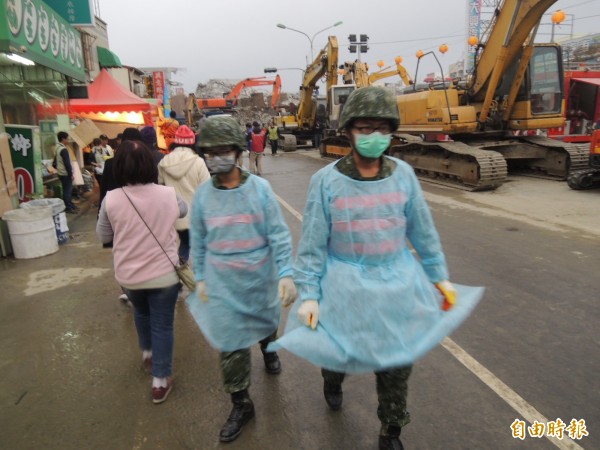 下午災區降下間歇雨勢，搜救人員穿雨衣持續作業。（記者蔡清華攝）