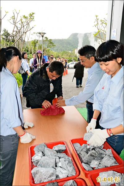 民眾將貫通石小心包在紅布內，準備拿去廟宇過爐。（記者朱則瑋攝）