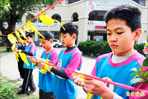 中山國小學童將心比心繫上黃絲帶，盼台南災民儘快重新站起來。（記者張聰秋攝）