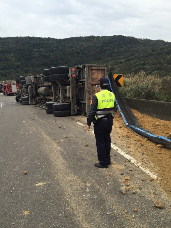 台2線106K砂石車翻覆，土石散落一地，警消齊力欲將受困駕駛救出。（記者吳昇儒翻攝）