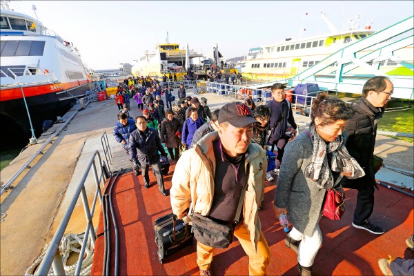 奉命撤離的白翎島居民20日搭船抵達仁川港。（美聯社）