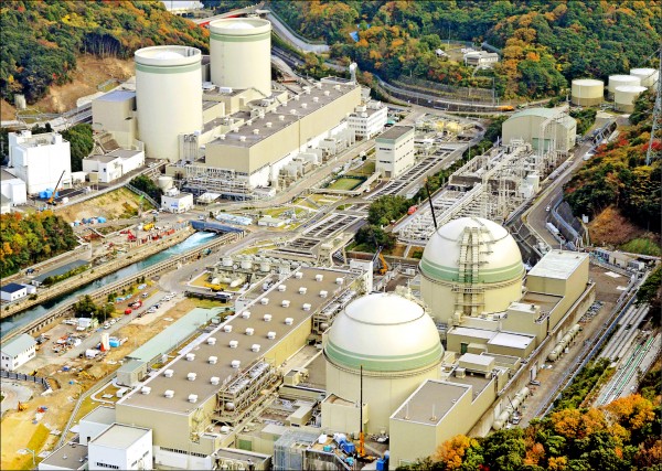 日本福井縣高濱核電廠4號機組（右下）廠房，發生輻射冷卻水外洩問題，原訂26日重啟的日程可能延後。（路透檔案照）