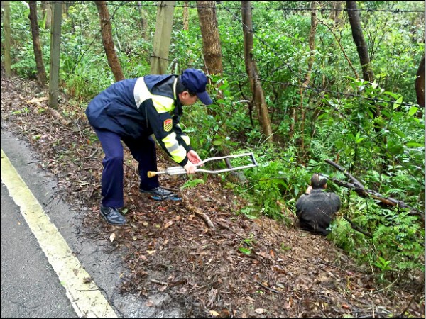 行動不便的汪男摔落邊坡，員警聽到野狗狂吠才發現，及時將他救出。（警方提供）