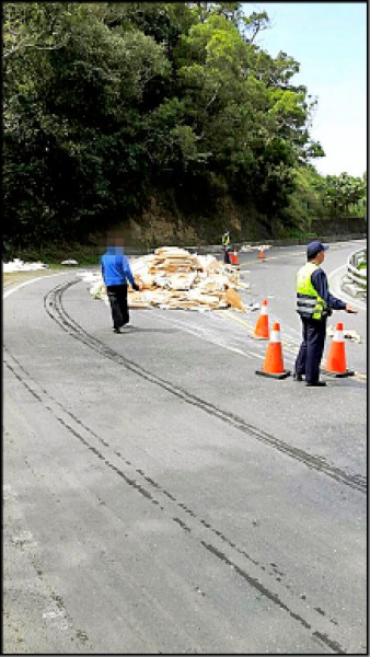 曳引車裝載的紙張掉落路中，警方動員交管防意外。（記者陳賢義翻攝）