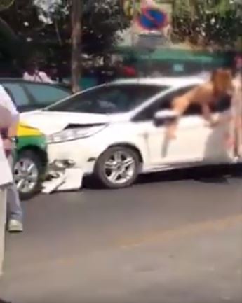 泰國一名女駕駛在發生車禍後，竟全裸爬出車窗外，有民眾拿棉被蓋在她身上還遭到拒絕。（圖擷取自YouTube）