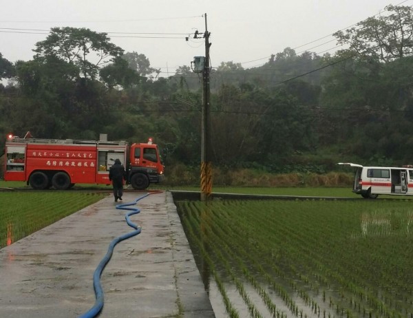 起火的民宅位在田埂小路盡頭，消防車進不去，打火弟兄跑步拉水帶進入灌救。（民眾提供）