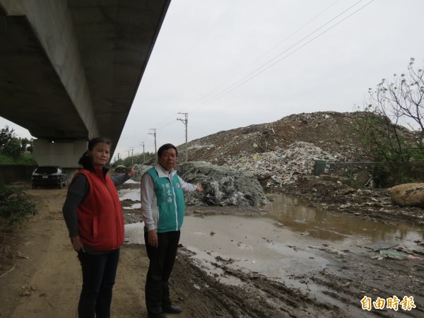 事業廢棄物堆的跟高鐵高架橋一樣高，市議員何文海（右）要求環保局快處理。（記者蘇金鳳攝）