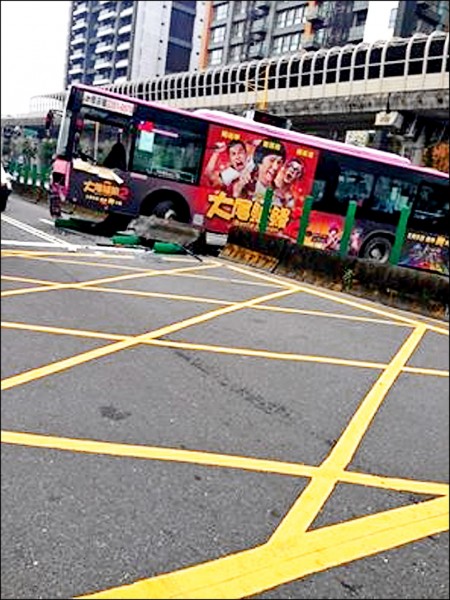 欣欣客運630公車昨打滑，整輛車竟「騎上」安全島動彈不得。（記者姚岳宏翻攝）