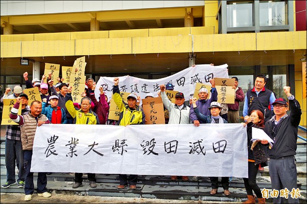 土庫鎮溪邊里農民拉白布條，抗議縣府徵用良田設置滯洪池。（記者林國賢攝）