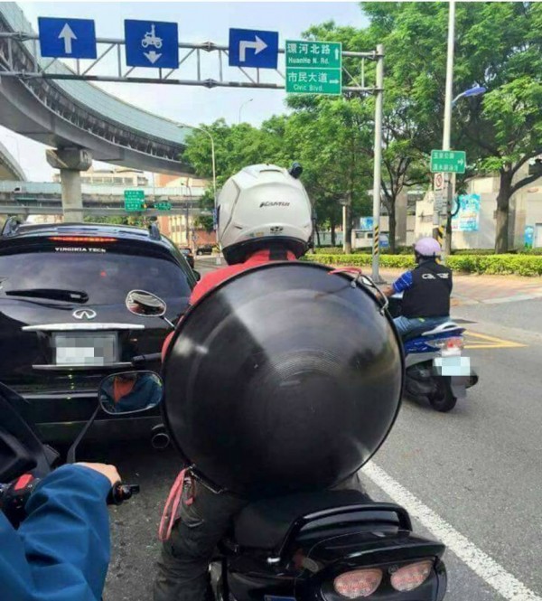 一名台北街頭的機車騎士竟把大炒鍋背在身上，就像是美國隊長背著盾牌一樣，網友們紛紛直呼他是「台灣隊長」（圖擷自爆料公社）