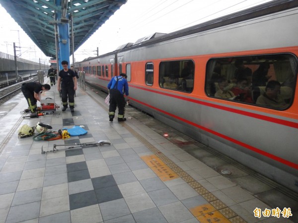  一名男子今下午在浮洲火車站疑因站得超過月台警戒線，遭途經自強號撞上，消防員救出他送醫。（記者吳仁捷攝）