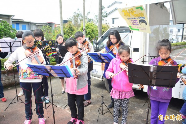 宜蘭市五大社區小提琴班為籌措外縣市演出旅費，走上街頭演出與義賣。（記者游明金攝）