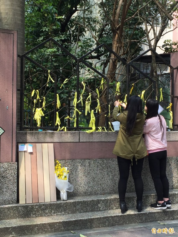 民眾在案發地的對街，西湖國小的牆上繫上黃絲帶。（記者陳恩惠攝）