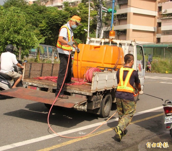 南投市公所派員在街頭噴藥防治登革熱。（記者謝介裕攝）