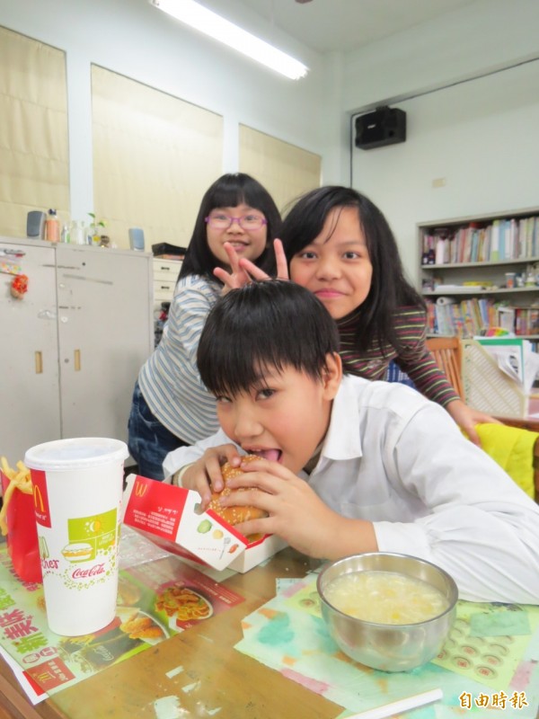 歡度兒童節，基隆港西國小讓學生自己票選午餐吃啥，最後學生選擇吃漢堡、薯條，小朋友在校內吃到漢堡薯條樂不可支。（記者俞肇福攝）