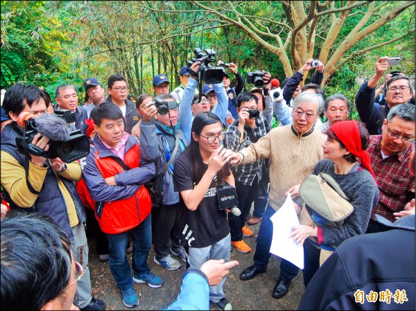 文資委員到場時，受到普安堂支持者的包圍關切。（記者翁聿煌攝）