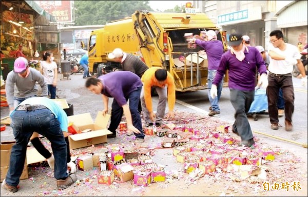 彰化市南瑤宮媽祖回鑾行經市區時，留下滿地鞭炮屑，市公所清潔隊員沿途收垃圾。（記者湯世名攝）