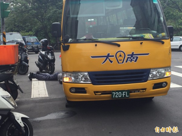 北市北投區今天下午驚傳公車壓傷人事件，原來是公車拋錨，司機自己動手處理啦！（記者陳恩惠攝）