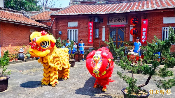 新竹縣新豐國中騎鐵馬踏查家鄉，昨天在周家三合院前展演舞獅和客家八音的學習成果。（記者廖雪茹攝）