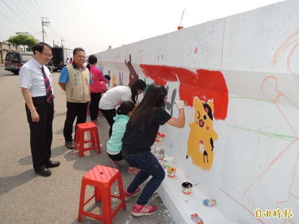 南市公益社團結合南區灣裡在地中學生彩繪二仁溪堤岸牆。（記者王俊忠攝）