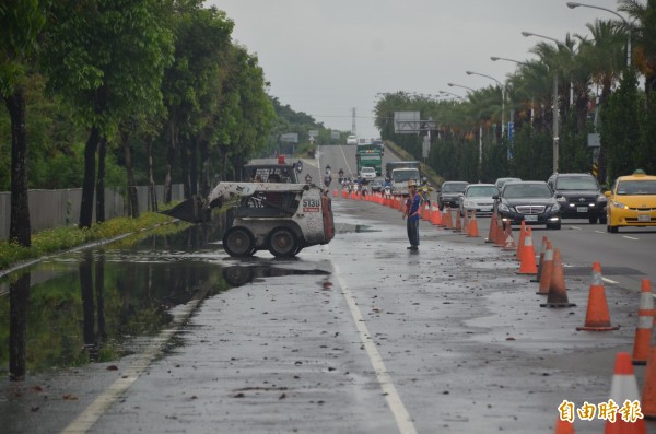 屏東大雨造成高屏大橋下方積水封閉車道，工程人員正進行清除作業。（記者葉永騫攝）