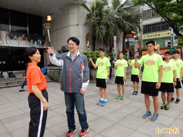 全國中等學校運動會將於23日在台東縣舉辦，圖為基隆市長林右昌將聖火傳遞給教育處長陳素芬。（記者俞肇福攝）